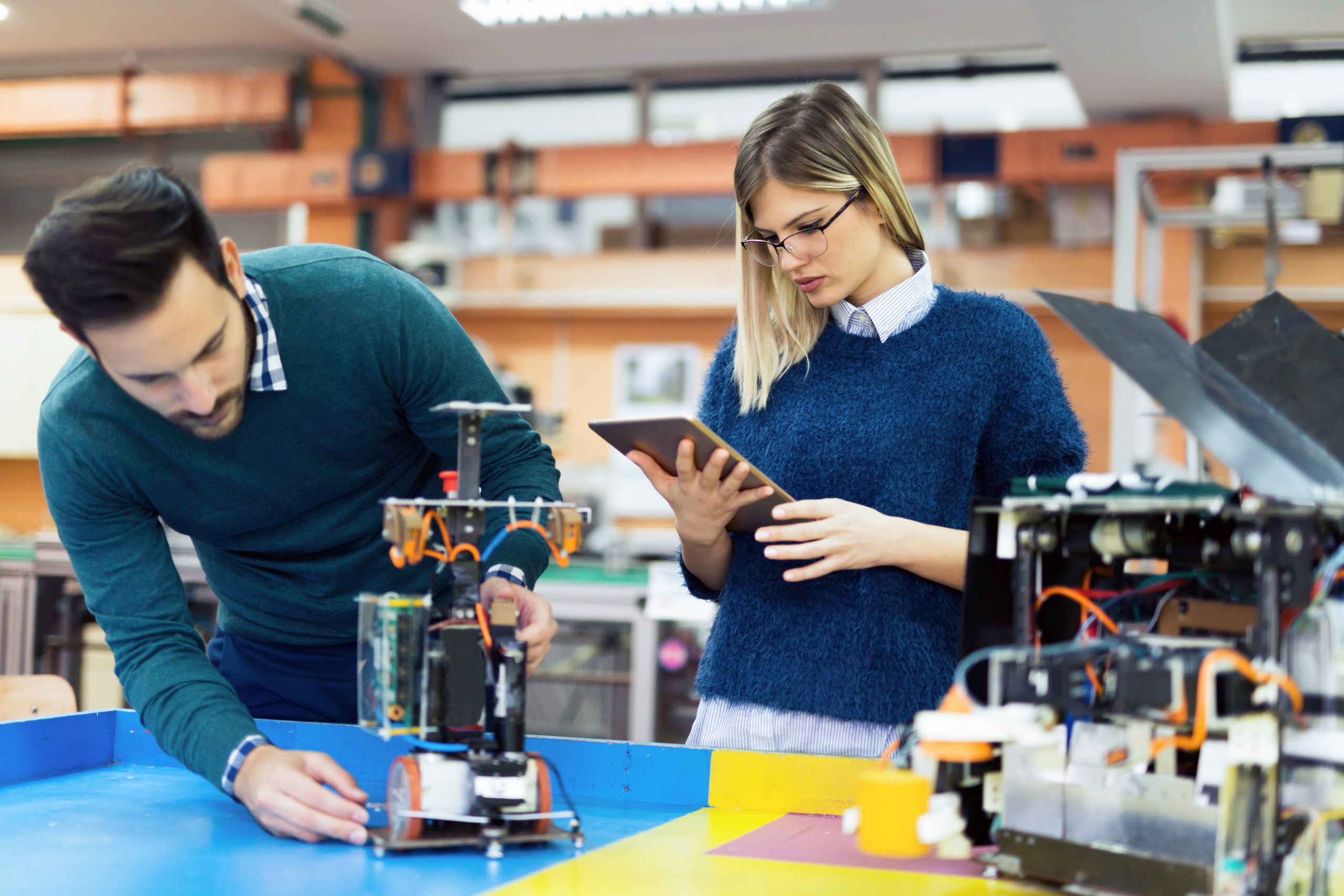 Industrial design vs product design represented as young man and young woman work on an electronic device