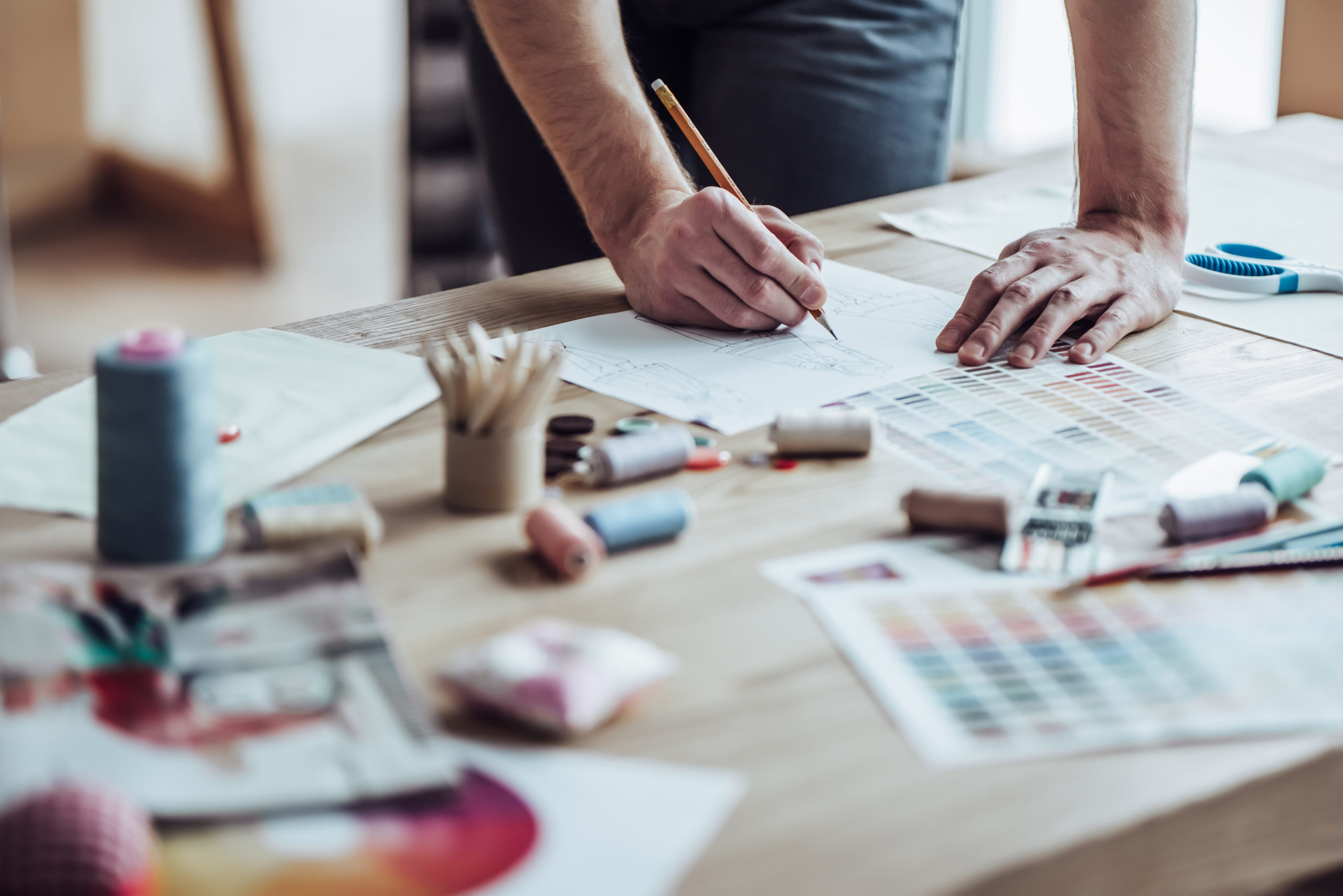 Man designing and prototyping soft goods with materials scattered around him
